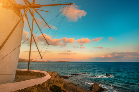Picturesque view of sea with Mykonos windmill at sunsetの写真素材