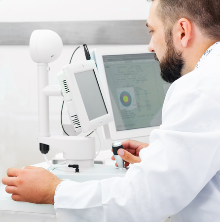 Doctor is working with diagnostics devices for patient examination in the ophthalmologic clinic