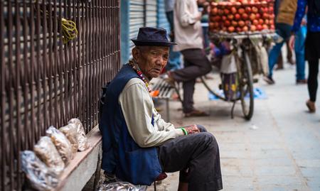 Kathmandu, Nepal - 06 October 2017: Portrait of old nepalese man in blue hat and rosaries on his...