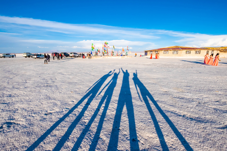 Salar de Uyuni, Bolivia - 21 October 2018: Shadow of four people with raised hands on white surfaceのeditorial素材