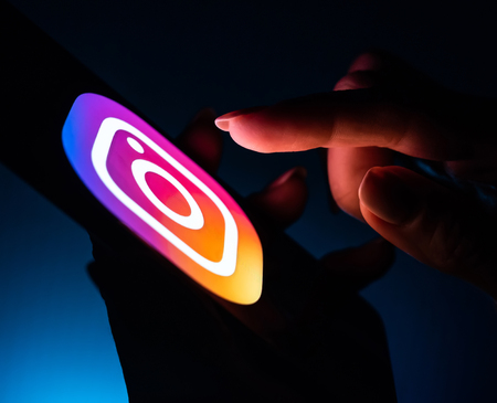 Kharkiv, Ukraine - 16 November 2018: close up girl hand using smartphone with instagram app on the screen with a dark backgroundのeditorial素材