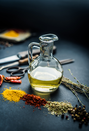 Colourful spices with oil on a black kitchen tableの写真素材