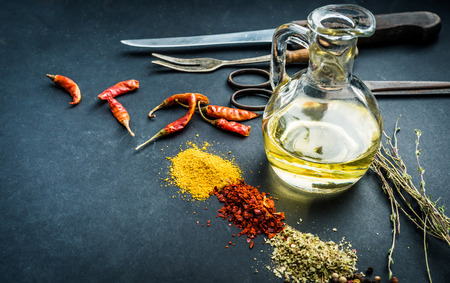 Colourful spices with oil on a black kitchen tableの写真素材