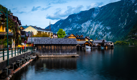 Evening scenery of lake and wooden buildings at the berth on the background of mountains in Hallstatt, Austriaの写真素材