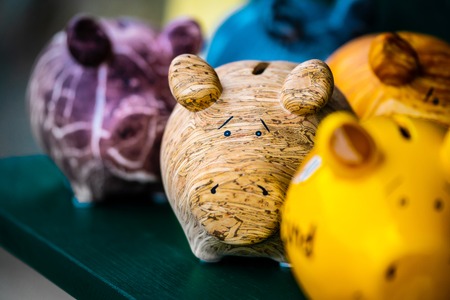 Colorful ceramic pig shape copycats on the wooden shelfの写真素材