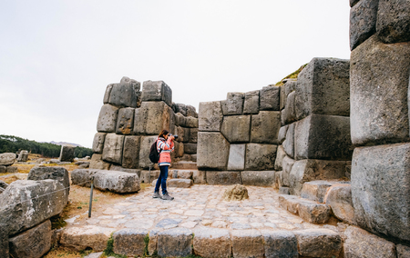 Girl taking photo of stone ancient wall in Sacsayhuamanの写真素材