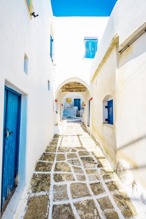 Scenic view of an old narrow stone paved lane with white houses, blue doors and an arch, Lefkes, Greeceの写真素材