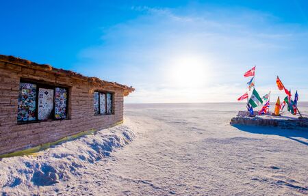 Salar de Uyuni, Bolivia - 21 October 2018: Sunshine place with different flags and building with stickers on windowsのeditorial素材