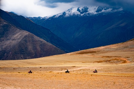Quard bike drivers riding on slope in mountanious Peruの写真素材
