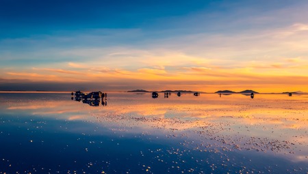 Amazing Salar de Uyuni mirror surface scenery with tourists and cars