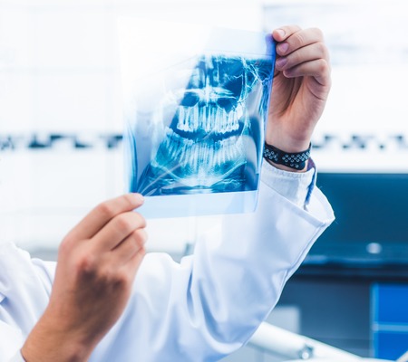Doctor in uniform holding x-ray snapshot