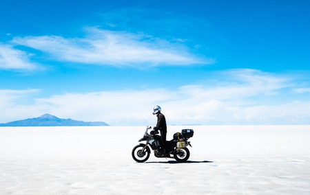 Tourist with equipment riding on motorbike in sunshine Salar de Uyuniの写真素材