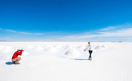 Tourists taking photos at sault banks on background of sunshine Salar de Uyuniの写真素材