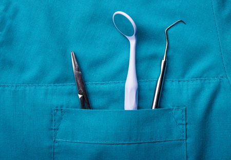 Closeup of dental tools in blue medical uniform pocketの写真素材