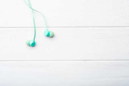 Digital light-blue earbuds on the minimalistic table, macro with copyspaceの写真素材