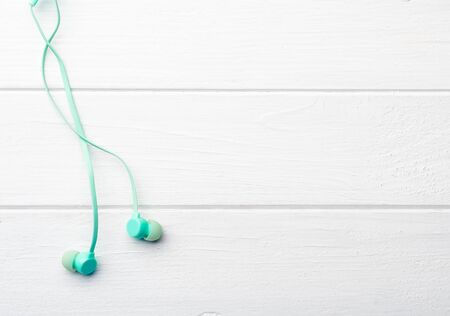 Azure silicon earphones on living room floor, with place for design