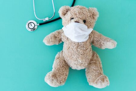 Teddy bear in medical mask near phonendoscopeの写真素材