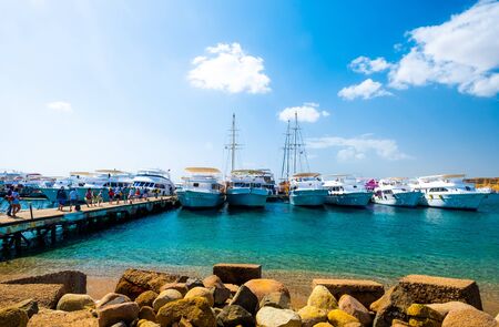 Beatiful view on naval harbor with white ships near old sandy mountains