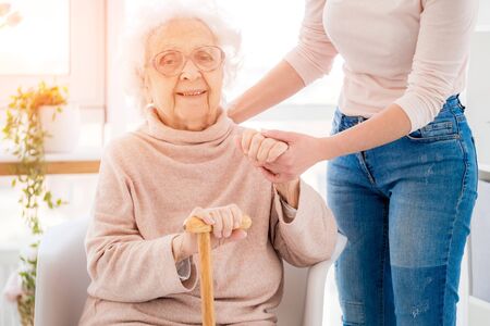 Lovely grandmother supported by young woman
