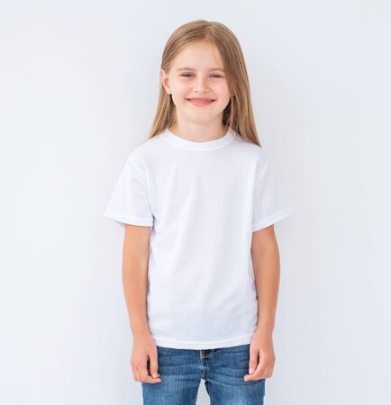 Funny little kid girl wearing a blank white t-shirt, isolated on white backgroundの写真素材