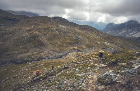 Hiking tourists high in alpine mountains