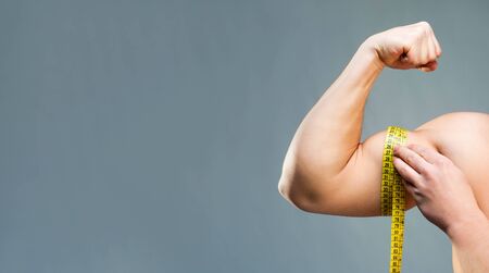 Strong athletic man measuring his handの写真素材