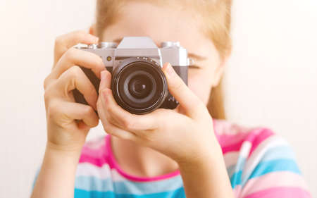 Close up view on photo camera with girl blurred on backgroundの写真素材