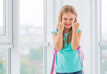 Young beatiful schoolgirl is so happy about her new year of education that she clenched her fists...