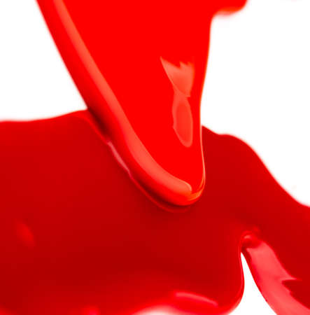 Colorful leaks of red liquid on white backgroundの写真素材