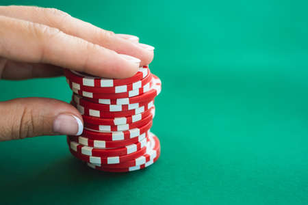 Casino chips on poker table held by woman handの写真素材