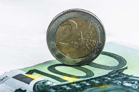 Euro currency one hundred banknote and two euro coinの写真素材