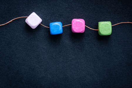 Bright wooden cube beads on thread macro with copy spaceの写真素材