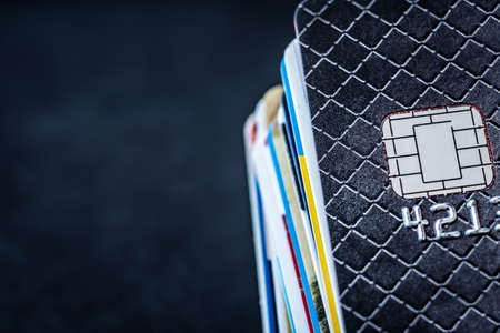 Credit cards stack on dark background with copy space
