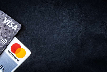 Kyiv, Ukraine - 03 June 2020: Visa and Mastercard credit cards and paper money with copy spaceのeditorial素材