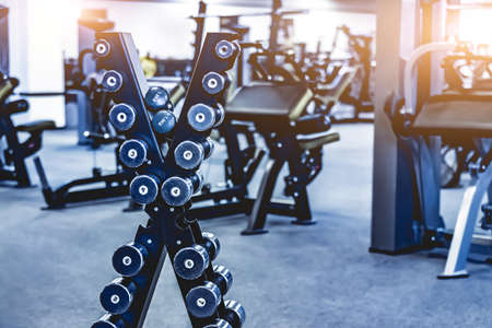 rows with a set of dumbbells and exercise equipment in modern gymの写真素材