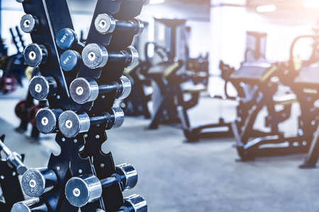 rows with a set of dumbbells and exercise equipment in modern athletic clubの写真素材