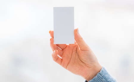Blank white business card in woman handの写真素材