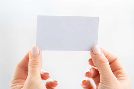 Hand holding empty white business cardの写真素材