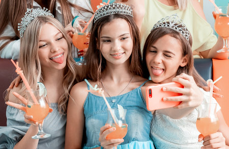 Funny girls taking selfie at birthday celebrationの写真素材