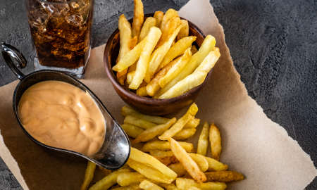 Close up view of delicious french fries with sauce and ice glassの写真素材