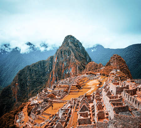 Breathtaking sunshine landscape of ancient majestic Machu Picchu city among high rocky mountains under the cloudsの写真素材