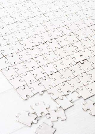 Little white pieces completing big blank puzzleの写真素材