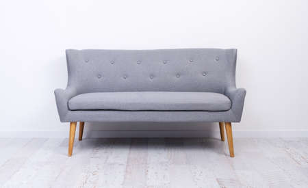 Gray couch standing on light laminate floor