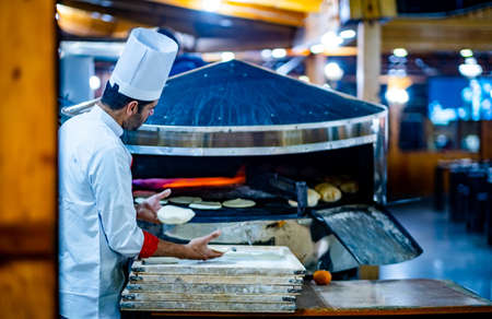 Arab chef preparing dinner in restaurant kitchenのeditorial素材
