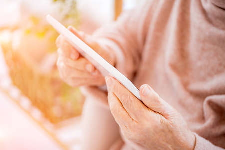 Elderly woman holding tablet