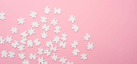 Scattering of puzzle pieces on pink backgroundの写真素材