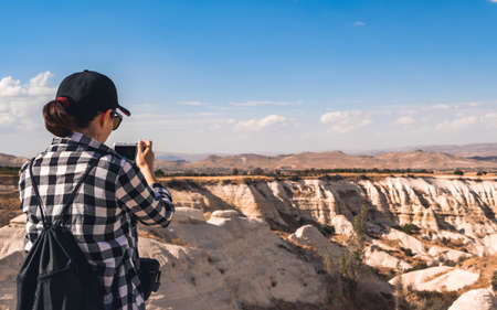 Tourist photographing canyon in Cappadocia, Turkeyの写真素材