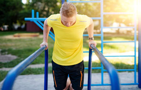 Man pulling up on parallel bars