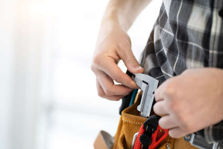 Hand pulling out caliper from belt