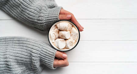 Woman holding cacao mug in hands